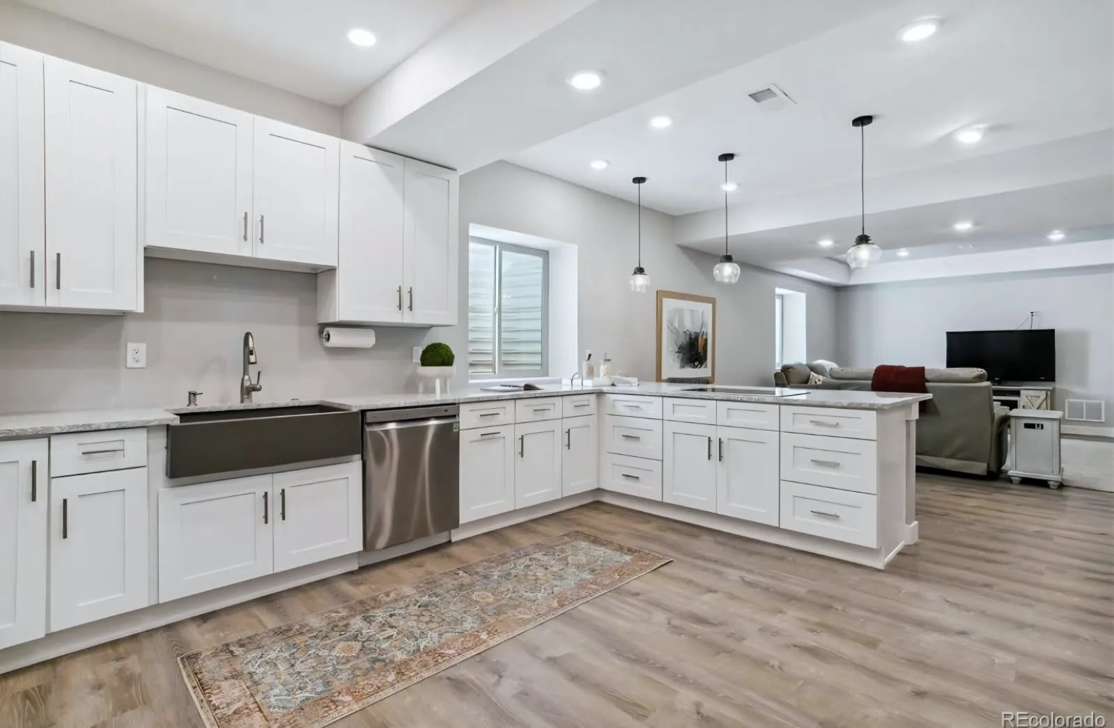 Finished basement family room with recessed lighting, barn door and luxury vinyl plank flooring